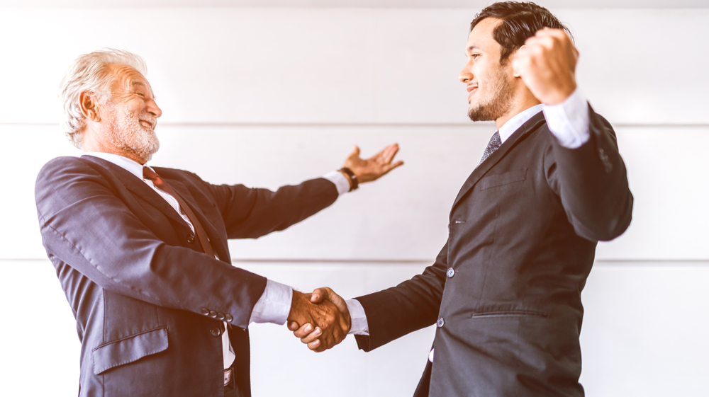Old man shaking hand with a business man