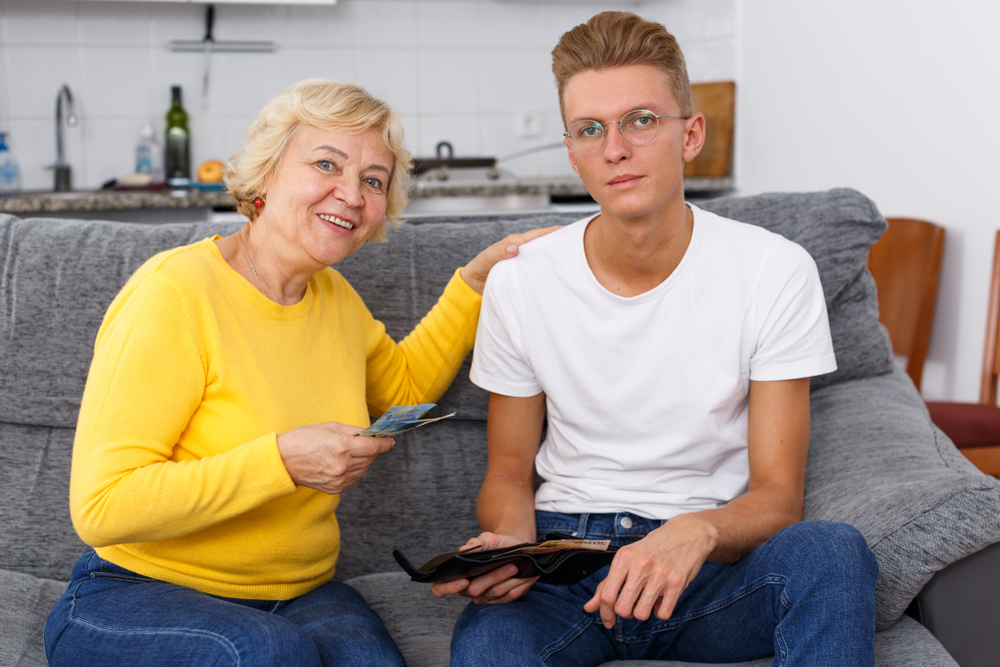 Senior woman giving money to her grown child